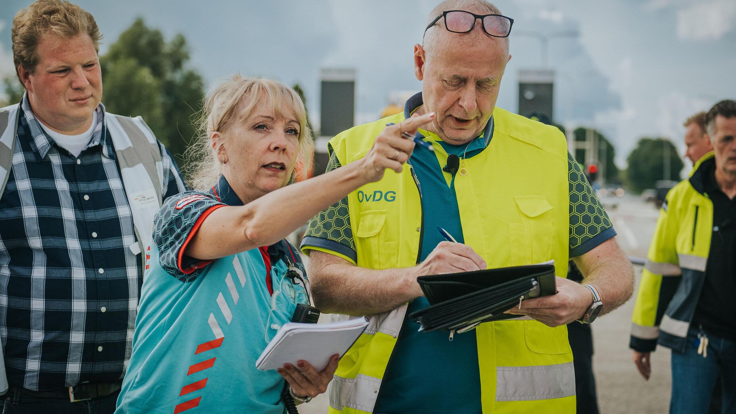 Ambulancevrouw geeft instructie aan GHOR waarnemer kijkt toe