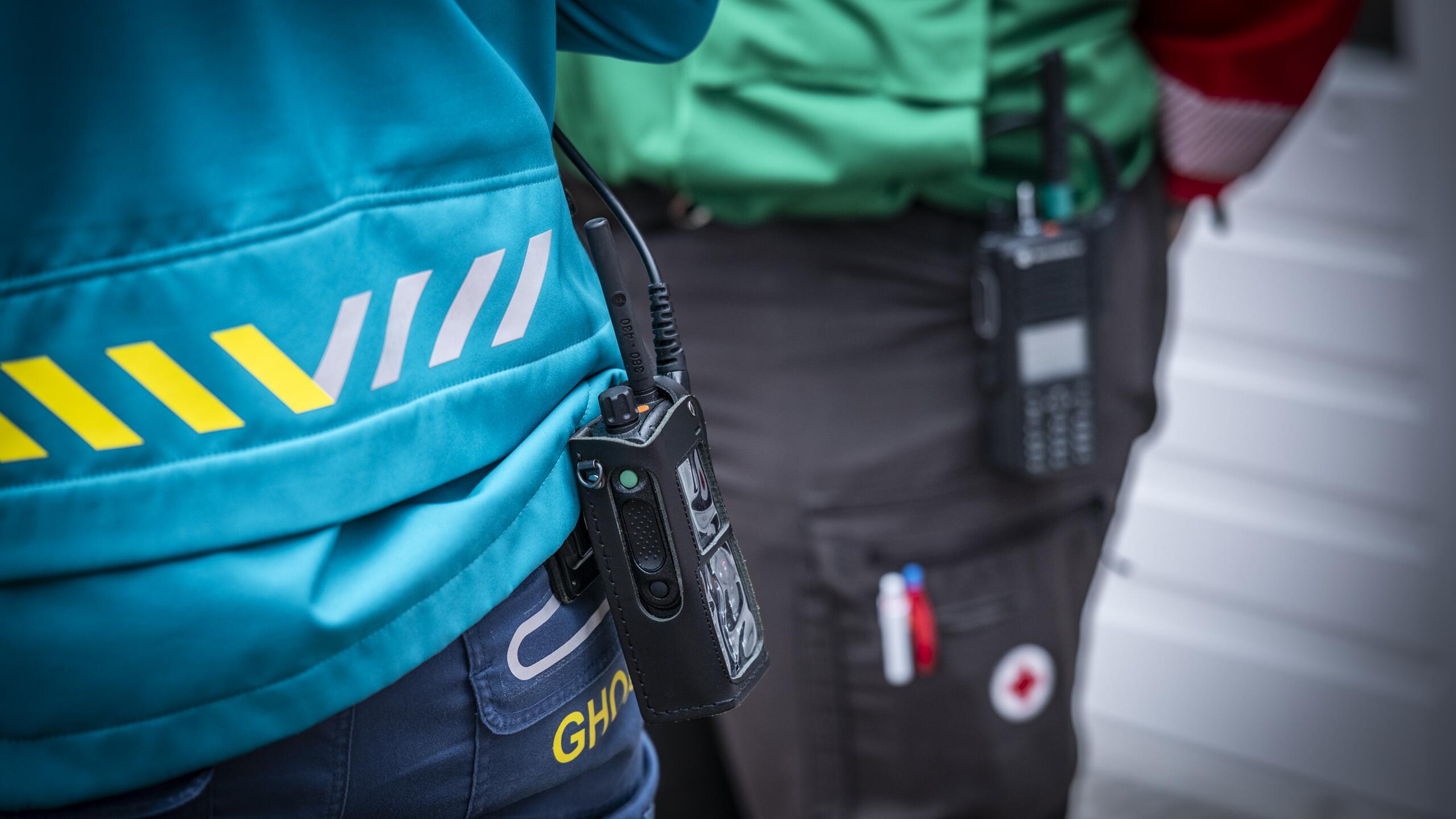 Detailfoto portofoon aan broek van GHOR-uniform en Rode Kruis-uniform