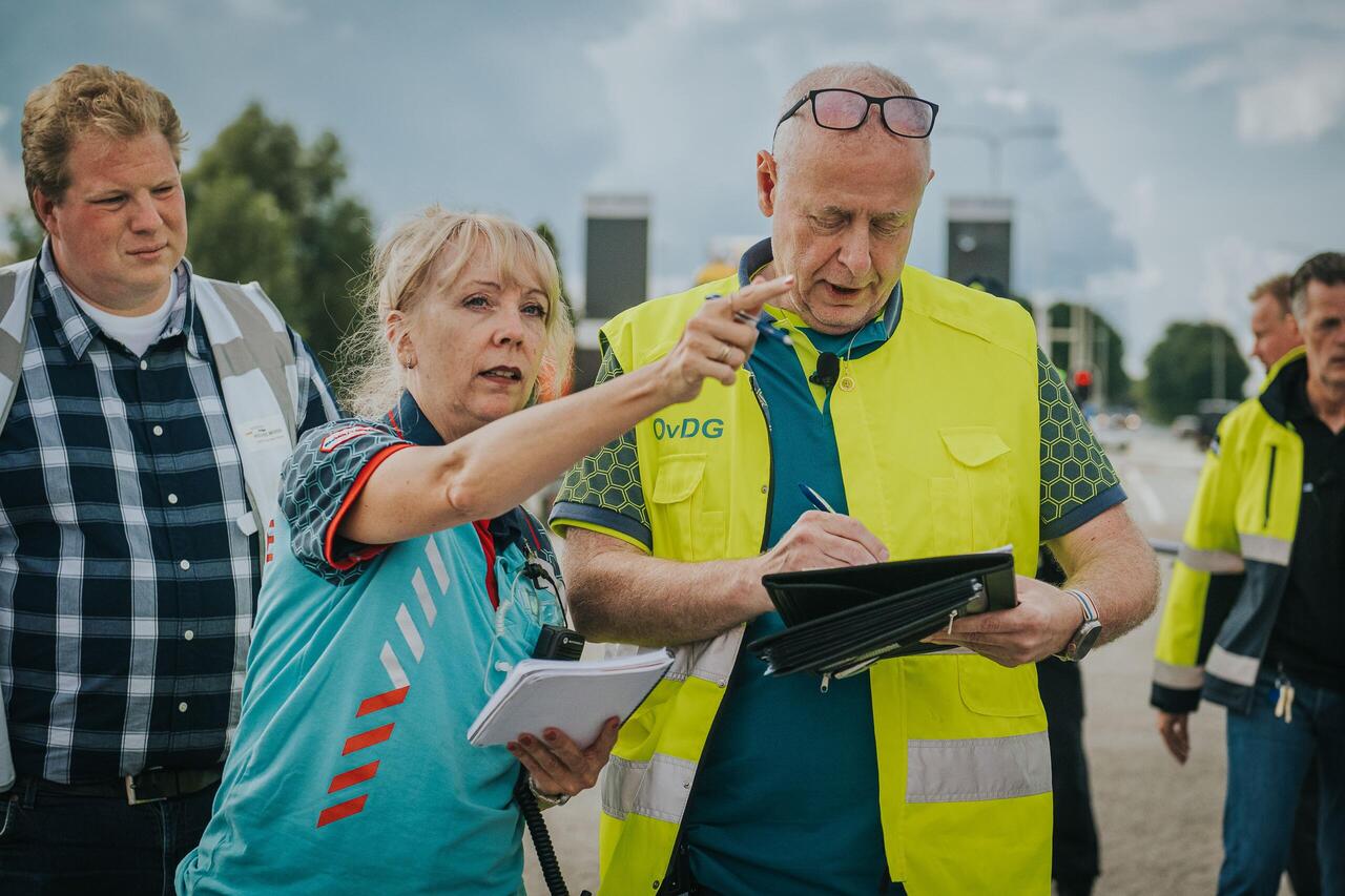 Ambulancevrouw geeft instructie aan GHOR waarnemer kijkt toe