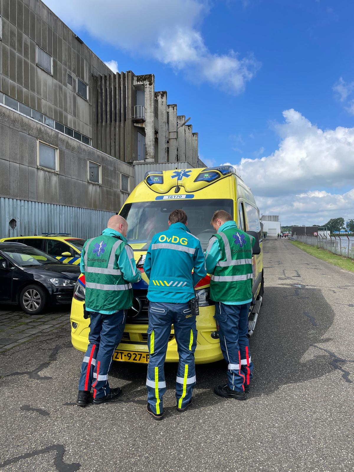 Motorkapoverleg drie mensen bij ambulance