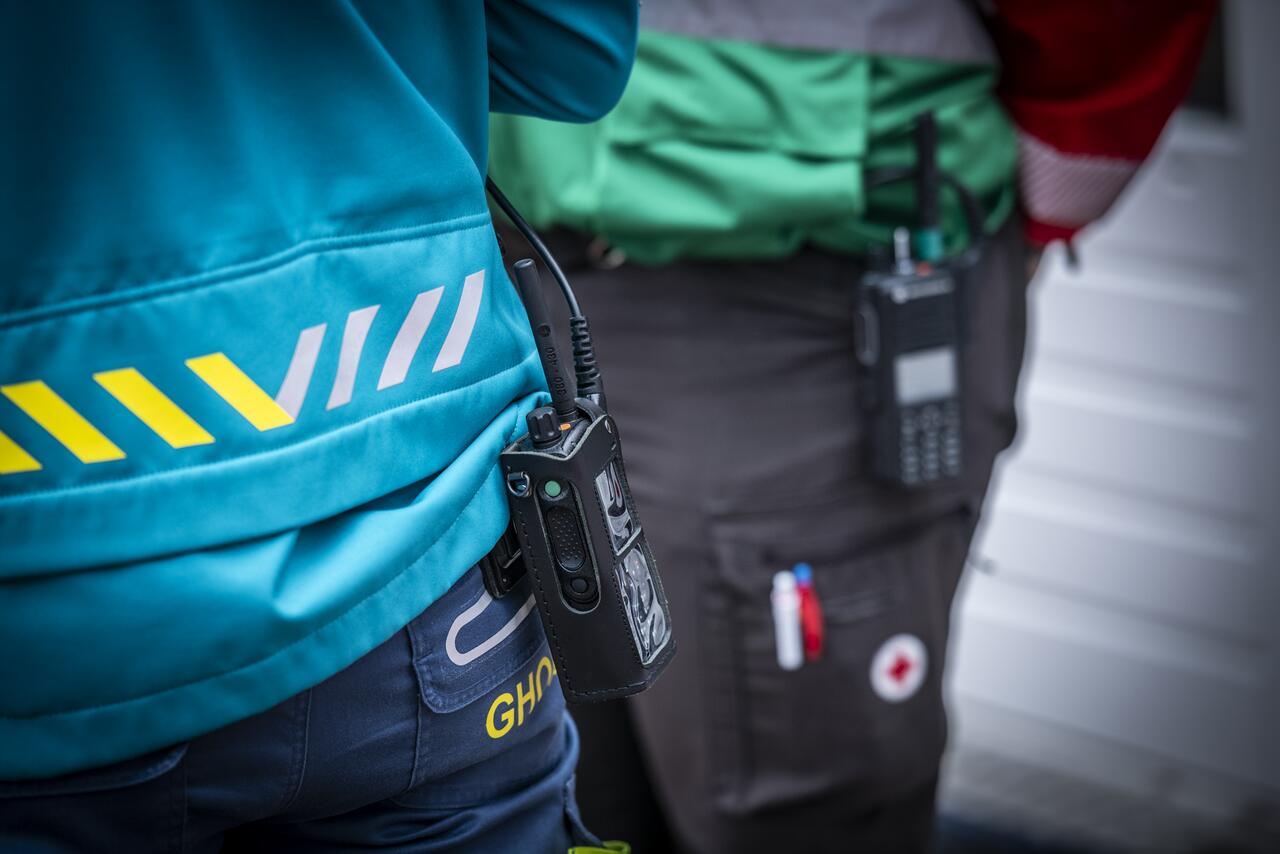 Detailfoto portofoon aan broek van GHOR-uniform en Rode Kruis-uniform