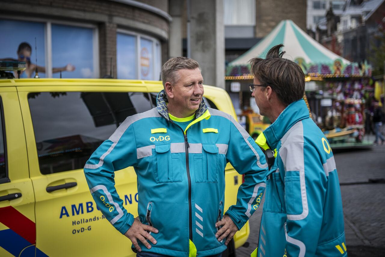 Officieren van Dienst Geneeskundig in gesprek tijdens Leidens Ontzet 2024, op achtergrond ambulance