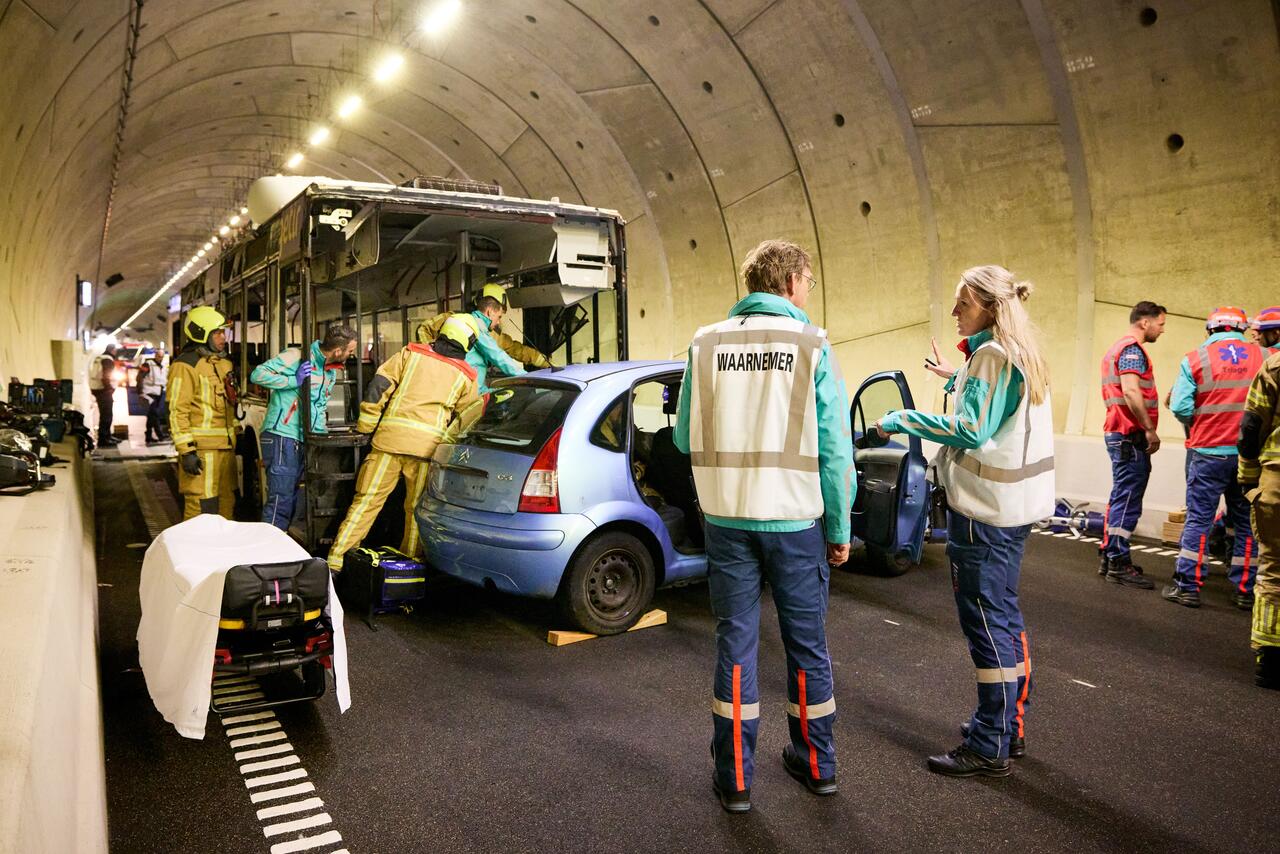 Auto, bus, botsing, in tunnel, hulpdiensten en waarnemers zichtbaar