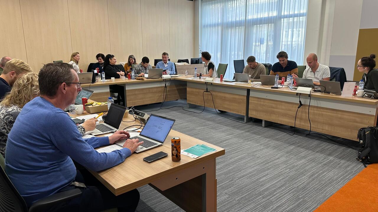 Mensen aan het werk aan grote u vorige tafel met laptops